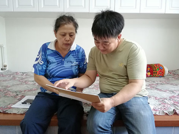 滕启刚妻子李淑华（左）向记者讲述滕启刚帮助他人的故事