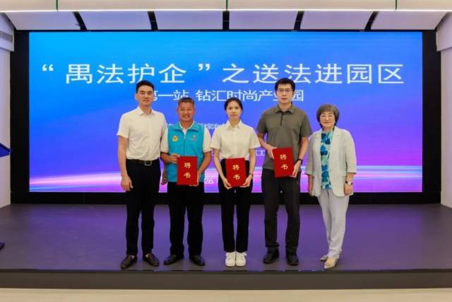 番禺区人大代表陈黎明（左一）参加番禺法院“禺法护企”之送法进园区活动，并为钻汇时尚产业园调解室的“枫桥护企专员”颁发聘书