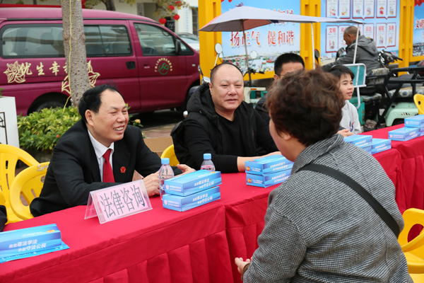 调解员崔焕忠与水产协会会长吴方权在侨港码头开展法律写传服务