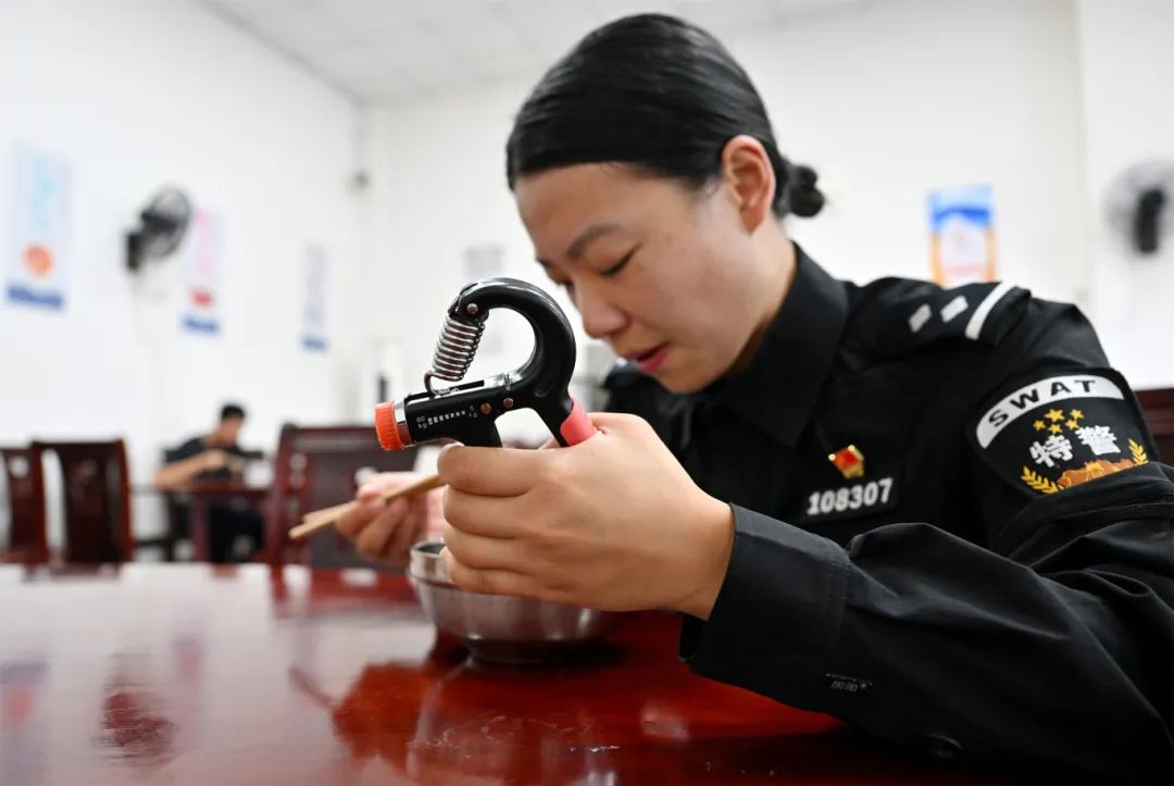 叶霞边吃饭边用握力器练习手部力量.JPG