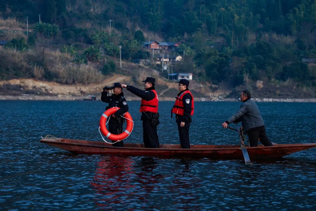 民警利用望远镜排查水库两岸安全隐患.jpg 民警利用望远镜排查水库两岸安全隐患.jpg