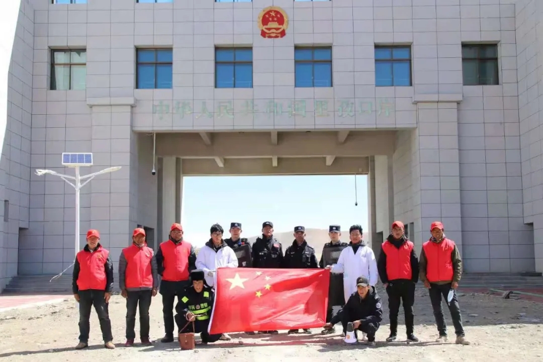 李玺(后排右一)和驻地疫情防控人员在在建的里孜口岸国门前合影